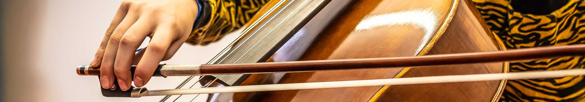 Jugendliche spielt auf einem Cello, Detailfoto des Cellokorpus