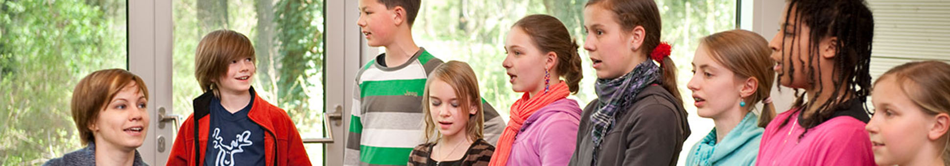 Musiklehrerin am Klavier und Jugendchor