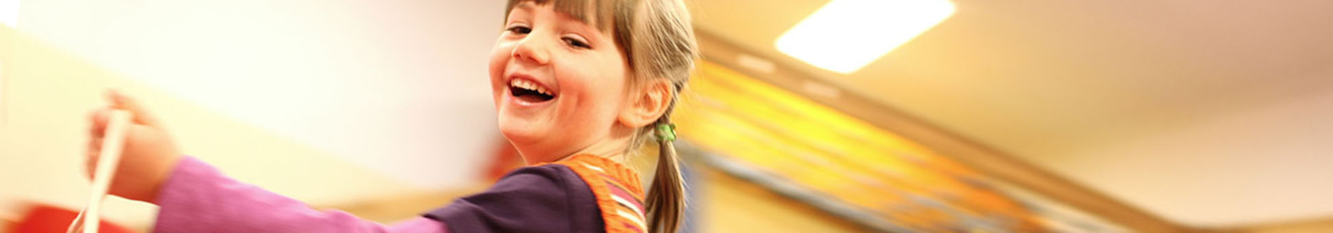 Kind tanzt ausgelassen im Turnraum