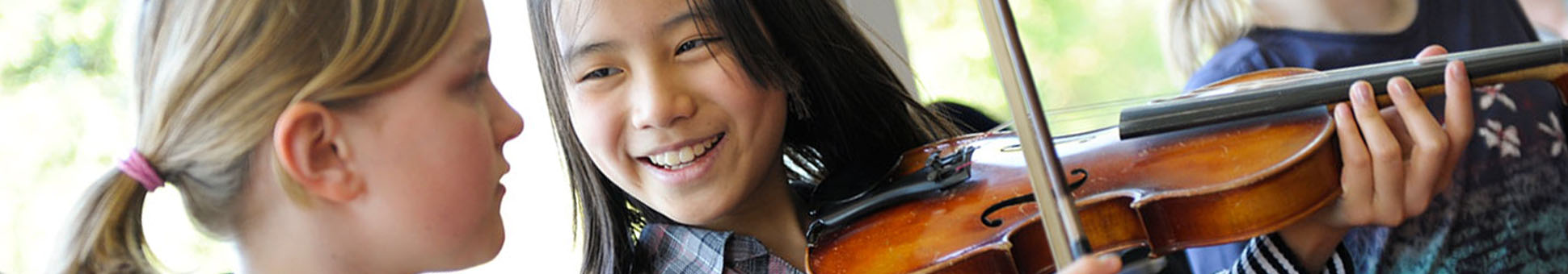 Drei Jugendliche üben Violine