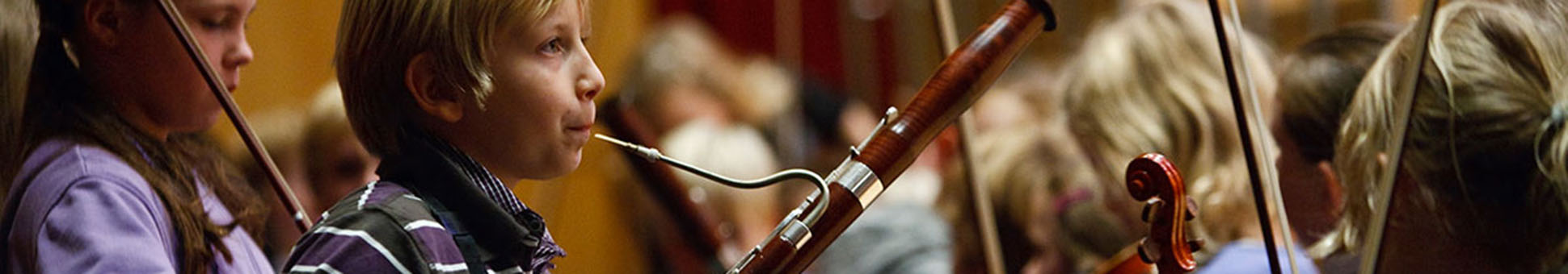 Ein Fagottspieler neben Streicher:innen im Jugendorchester
