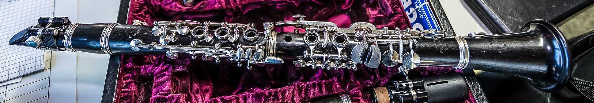Klarinettenkoffer mit einer demontierten Klarinette, darauf liegt ein komplettes Instrument