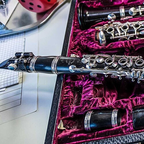 Klarinettenkoffer mit einer demontierten Klarinette, darauf liegt ein komplettes Instrument